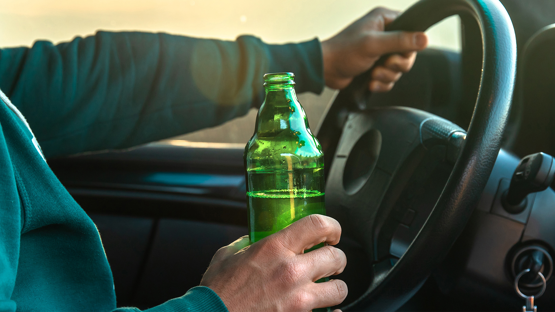 Man drinking beer while driving